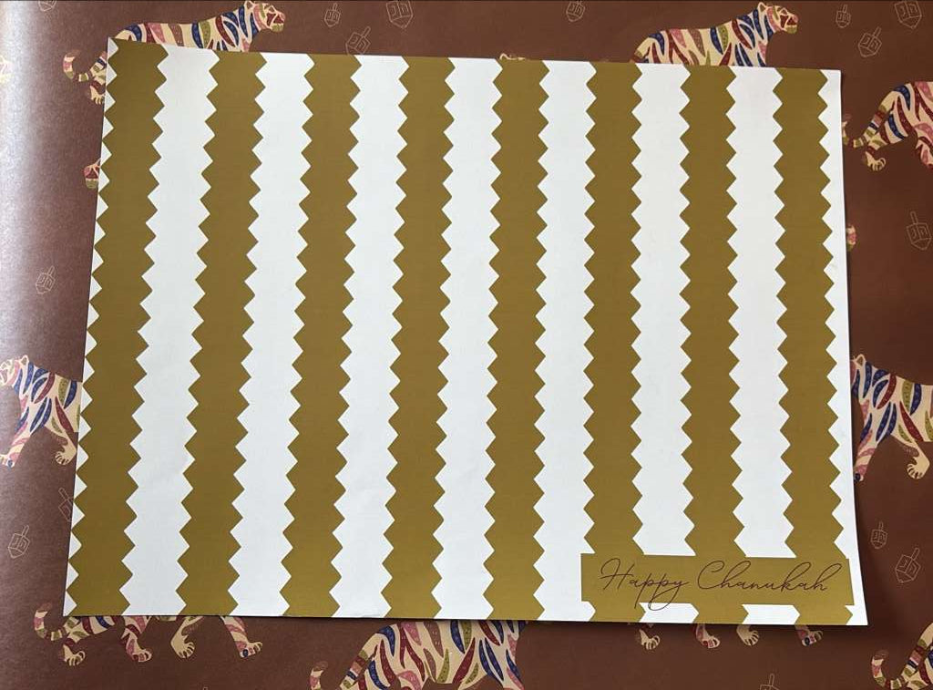 Decorative paper with gold and white wavy stripes on a patterned background